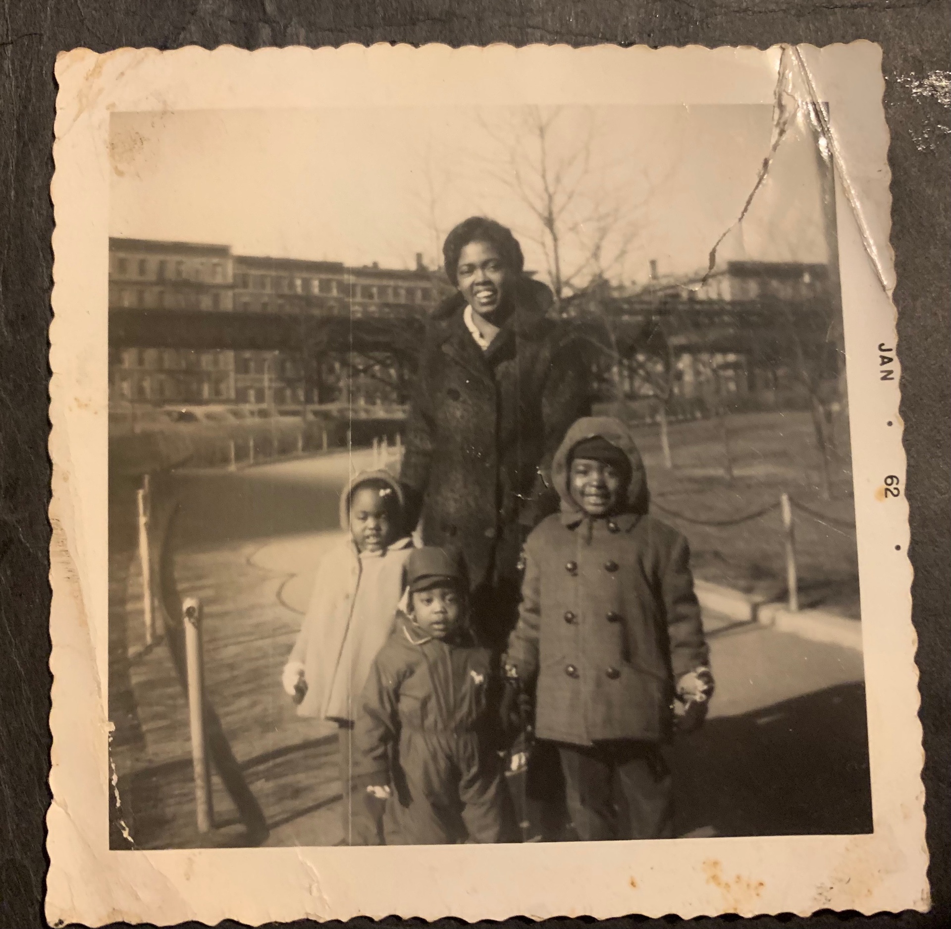Mother and three children bundled in winter coats, January 1962